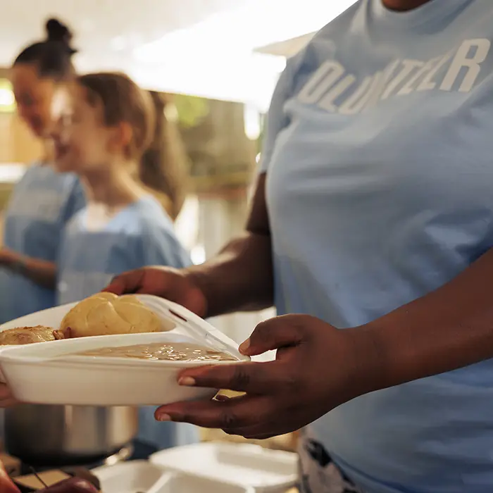 Church volunteer serving food at a community shelter